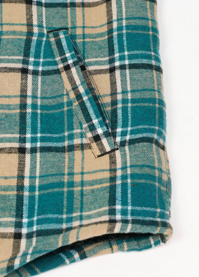 Close-up of the handpocket of a khaki green men's sherpa lined plaid flannel jacket