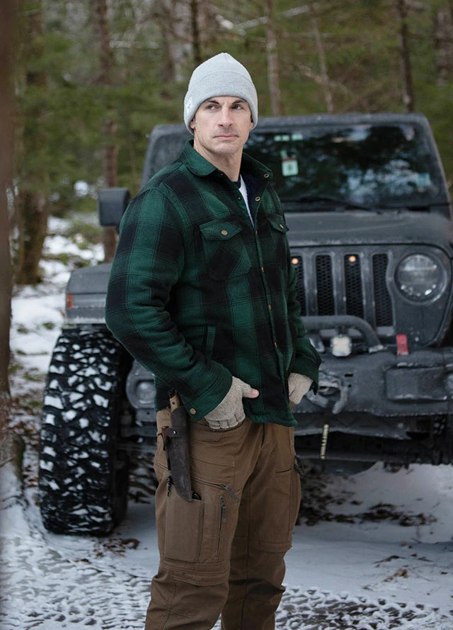 Front view of a man in a green black men's soft snap button flannel shirt jacket standing in front of the car