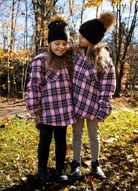 Two little girls, wrapped in Dawn Blush flannel, sharing warmth, comfort, and a quiet moment of togetherness