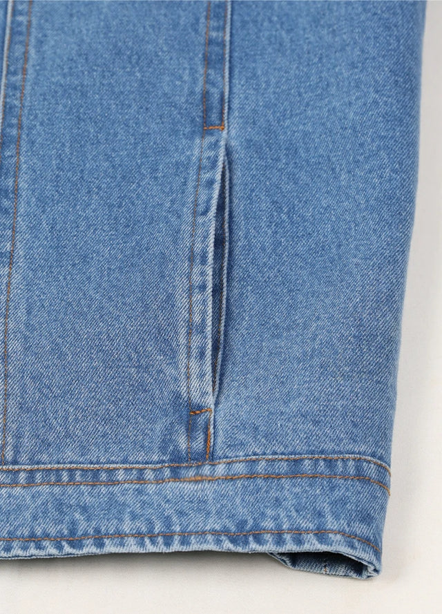 Detail view of the hand pocket of a blue denim shirt jacket for men