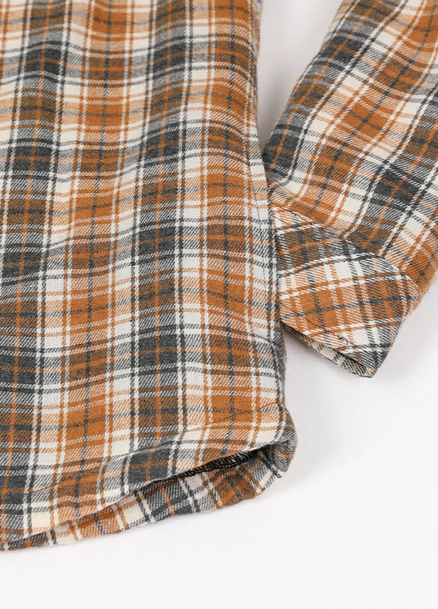 Zoomed-in of women's button down orange gray plaid flannel jacket hand pocket