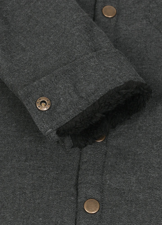 Close-up of cuff with button on kids black plaid flannel jacket