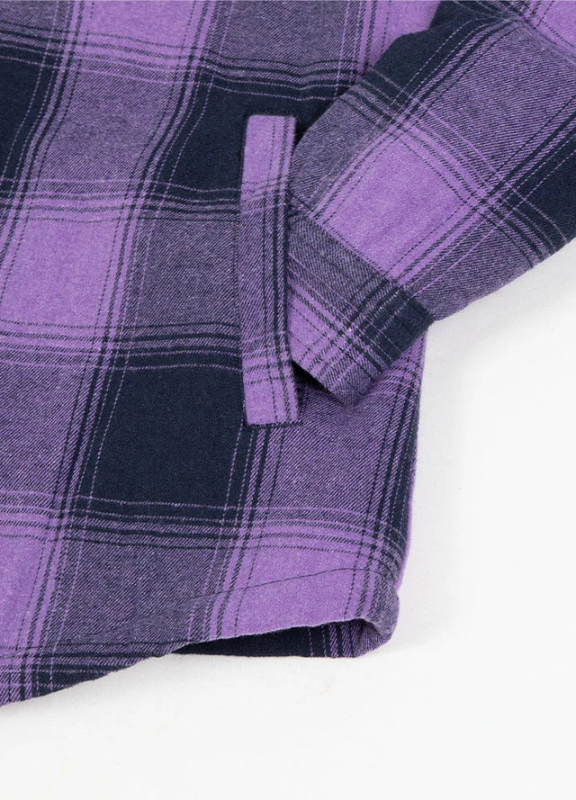 Close-up of women's purple plaid sherpa-lined shirt jacket hand pocket
