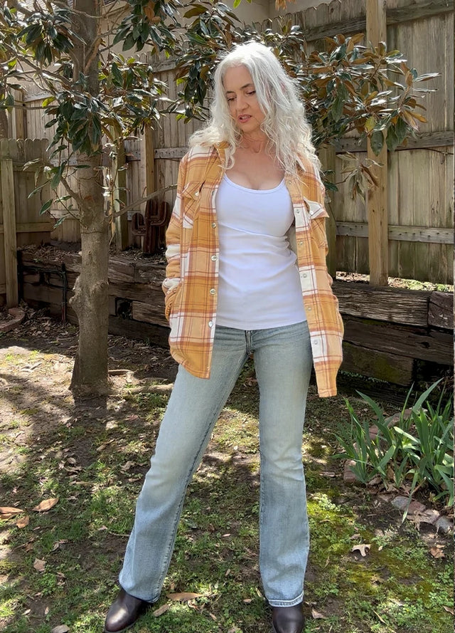 Women in a long-sleeve sherpa-lined yellow plaid flannel shirt jacket