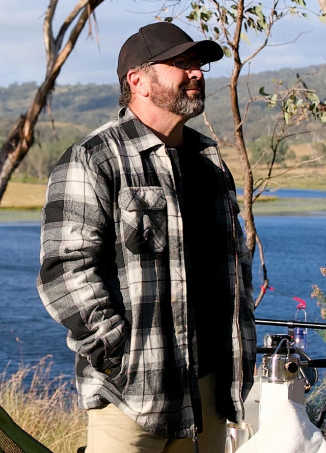 Front view of a man in a white and black men's full zip up plaid flannel jacket