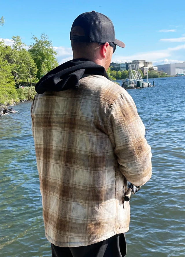 Back view of a man wearing a khaki men's flannel hooded jacket who is fishing