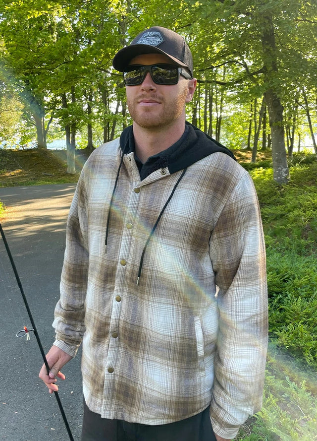 Front view of a man wearing a khaki men's flannel hooded jacket and holding a fishing rod