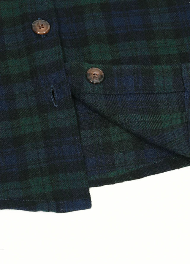 Detailed close-up of dark green plaid flannel shirt hem