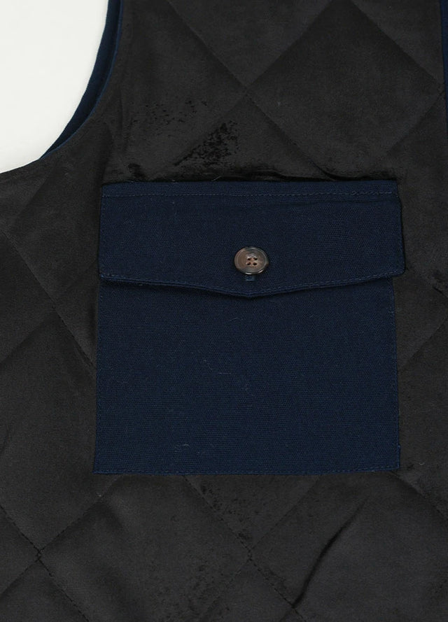 Close-up of the inner pocket with button closure on men's quilted canvas work vest