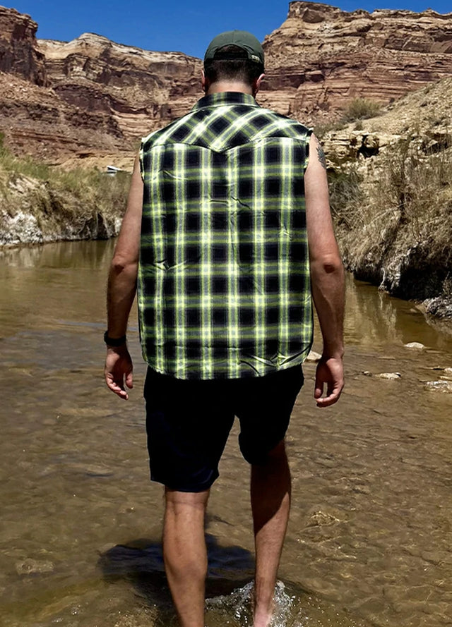 Back view of a man in a men's green cool snap pearl western plaid vest standing in the water