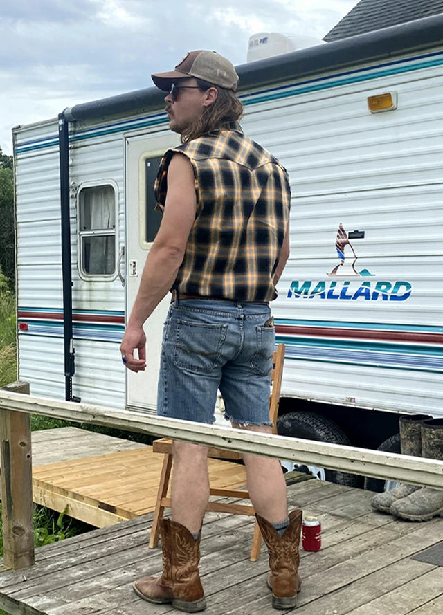 Back view of a man in a men's orange snap pearl western vest