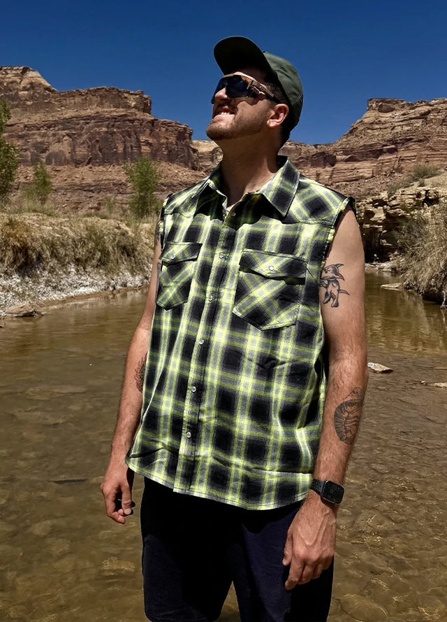 Front view of a man in a green cool snap pearl western plaid vest for men standing in the water