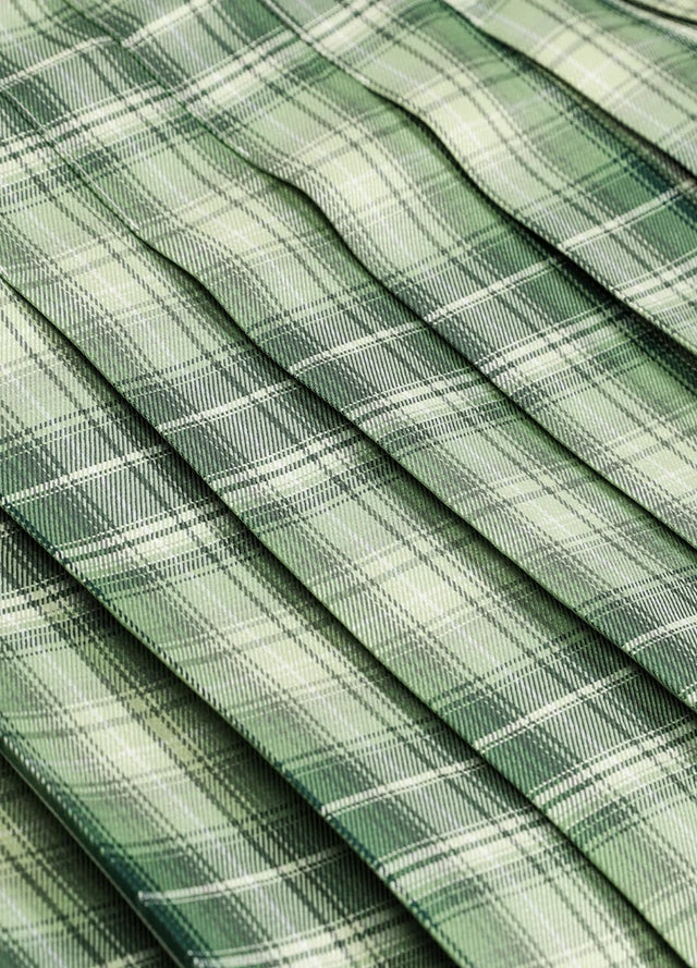 Close-up of the fabric on a women's green plaid elastic waist pleated skirt