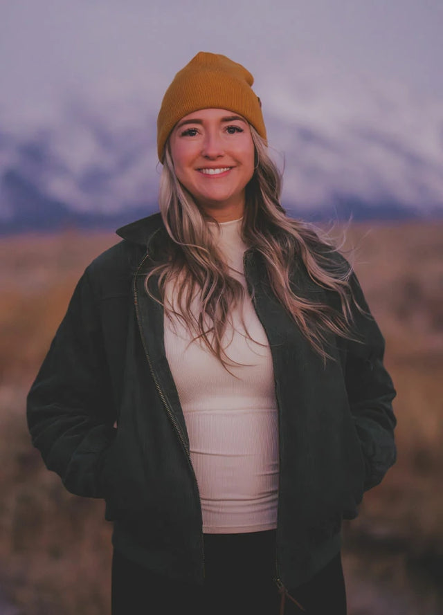 Women wearing a dark green long sleeves corduroy jacket with full zip