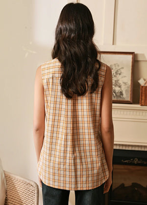 Back view of women in a sleeveless cotton orange white plaid vest