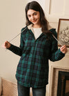 Women in a green black sherpa-lined flannel plaid jacket with hood