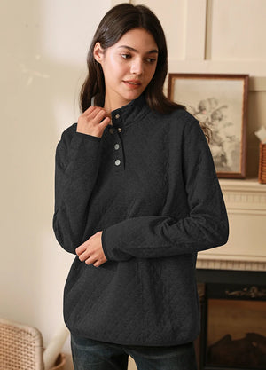 Women in a solid black 1/4 quilted fleece pullover with snap button