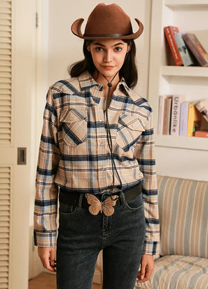Women in a khaki navy pearl snap western flannel plaid shirt