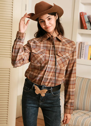 Women in a chocolate pearl snap western flannel plaid shirt