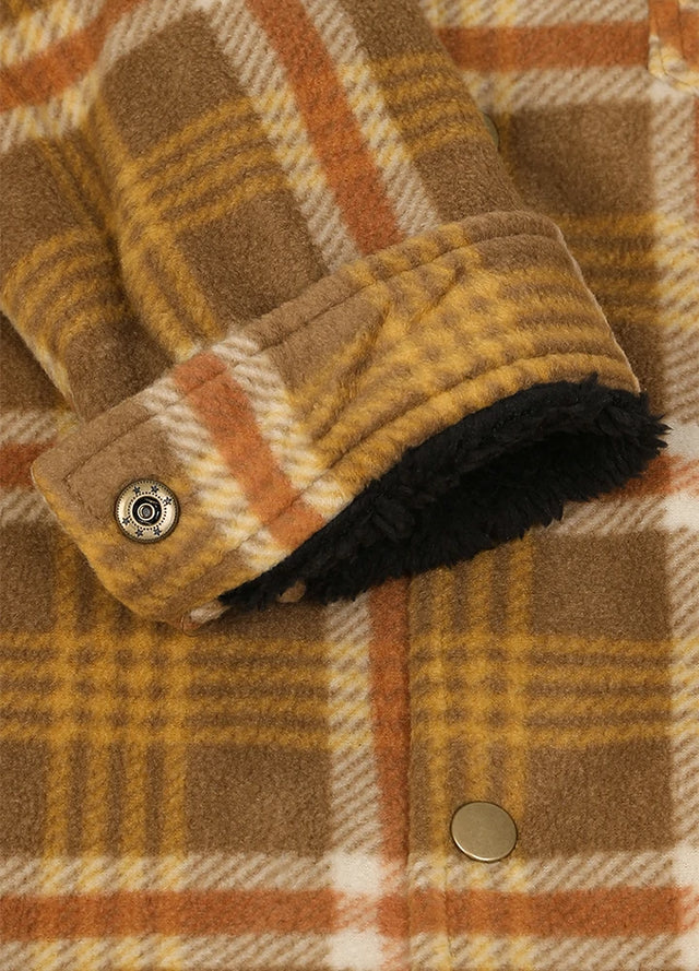 Close-up of a plaid fleece jacket with a warm brown, yellow, and orange pattern, featuring a black sherpa lining visible at the cuff and metal snap buttons.