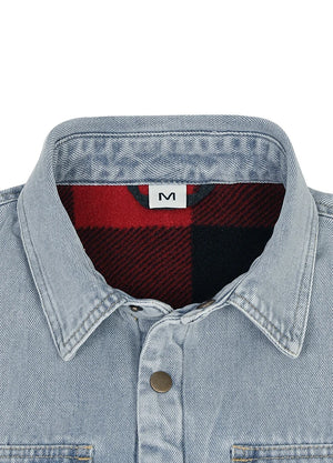 Close-up of a light blue denim button-up shirt collar with a red and black buffalo plaid lining visible inside the collar, and a small white size label with the letter M.