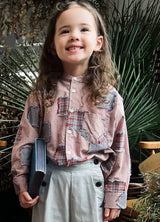 A smiling girl in pink toddler plaid patchwork long sleeve flannel shirt 