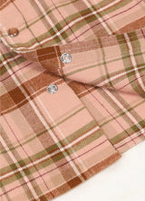 Detailed close-up of pearl snap on kids rose latte short-sleeve shirt