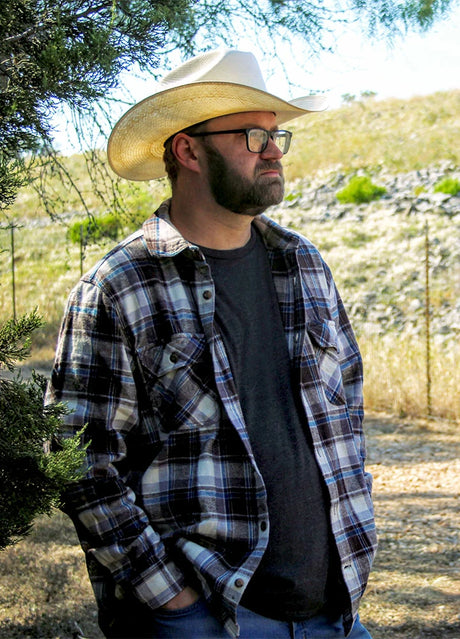 A man chopping wood in a coffee white men's stalwart heavyweight cotton plaid shirt