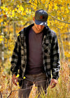 Front view of a man in a gray men's sherpa lined flannel shacket standing in the woods