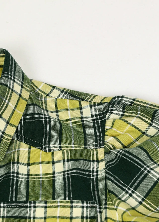 Close-up of the fabric on a women's green plaid cotton shirt dress