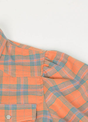 Close-up of the fabric on a women's orange plaid cotton shirt dress