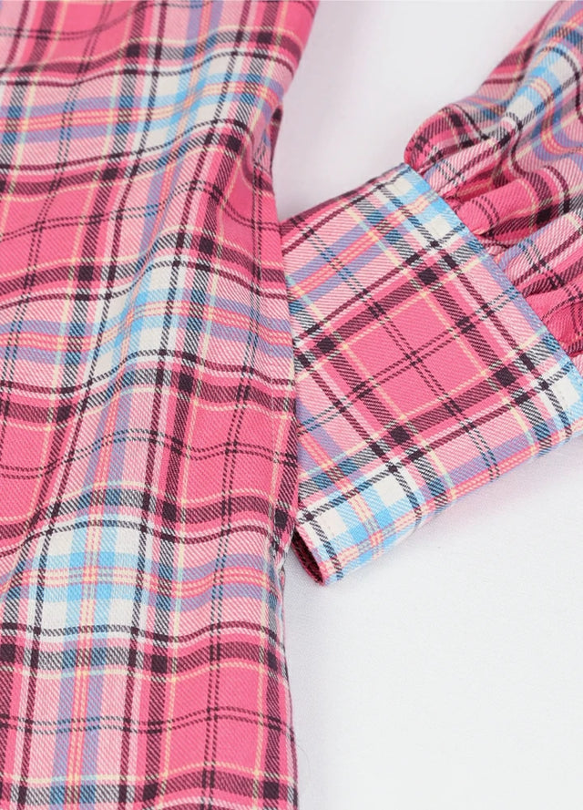Close-up of women's pearl snap pink flannel shirt dress hand pocket