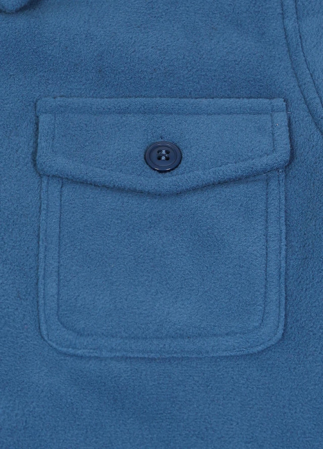 Detail of kids light blue flannel jacket pocket with button