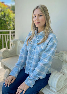 Side view of women in a baby blue flannel cropped plaid shirt
