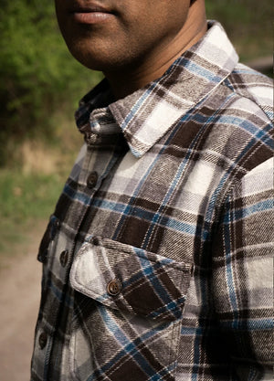 Close-up of the upper body of a man wearing a men's stalwart heavyweight cotton plaid shirt