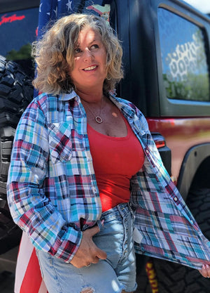 Side view of women in a long sleeve blue and white irregular plaid  shirt