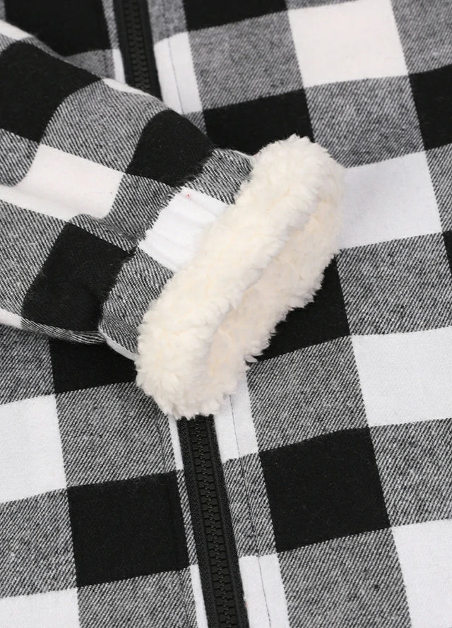 Close-up view of the elastic cuff with lambswool lining on the kid's full zip-up jacket in black and white