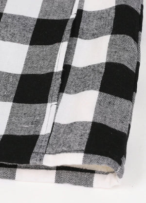 Close-up view of the hand pocket detail on the kid's full zip-up lambswool-lined jacket in black and white