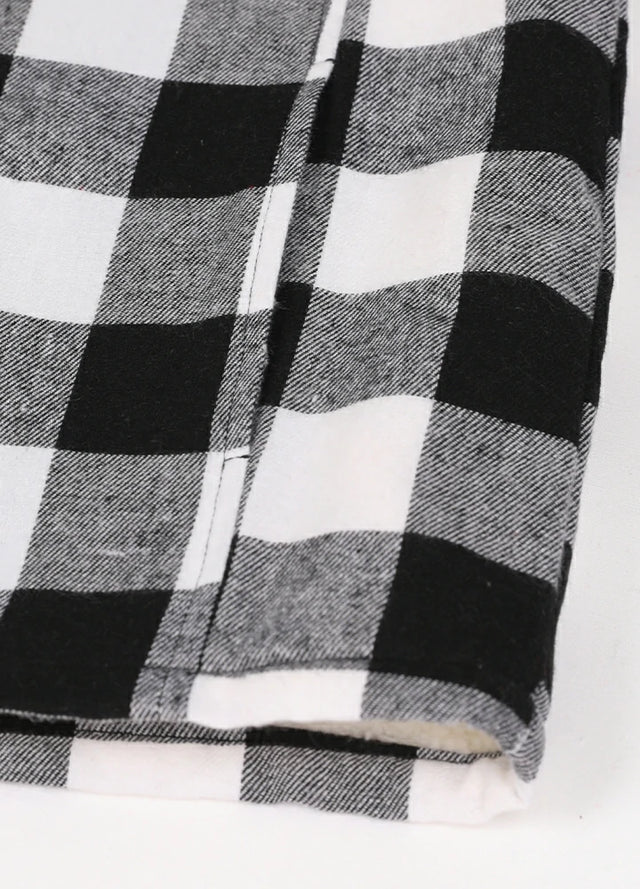 Close-up view of the hand pocket detail on the kid's full zip-up lambswool-lined jacket in black and white