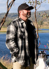 Front view of a man in a white and black men's full zip up plaid flannel jacket 