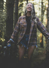 Women in a brown button down printed flannel plaid shirt
