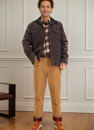 Front view of a man wearing khaki men's flannel lined pants standing in front of a wall
